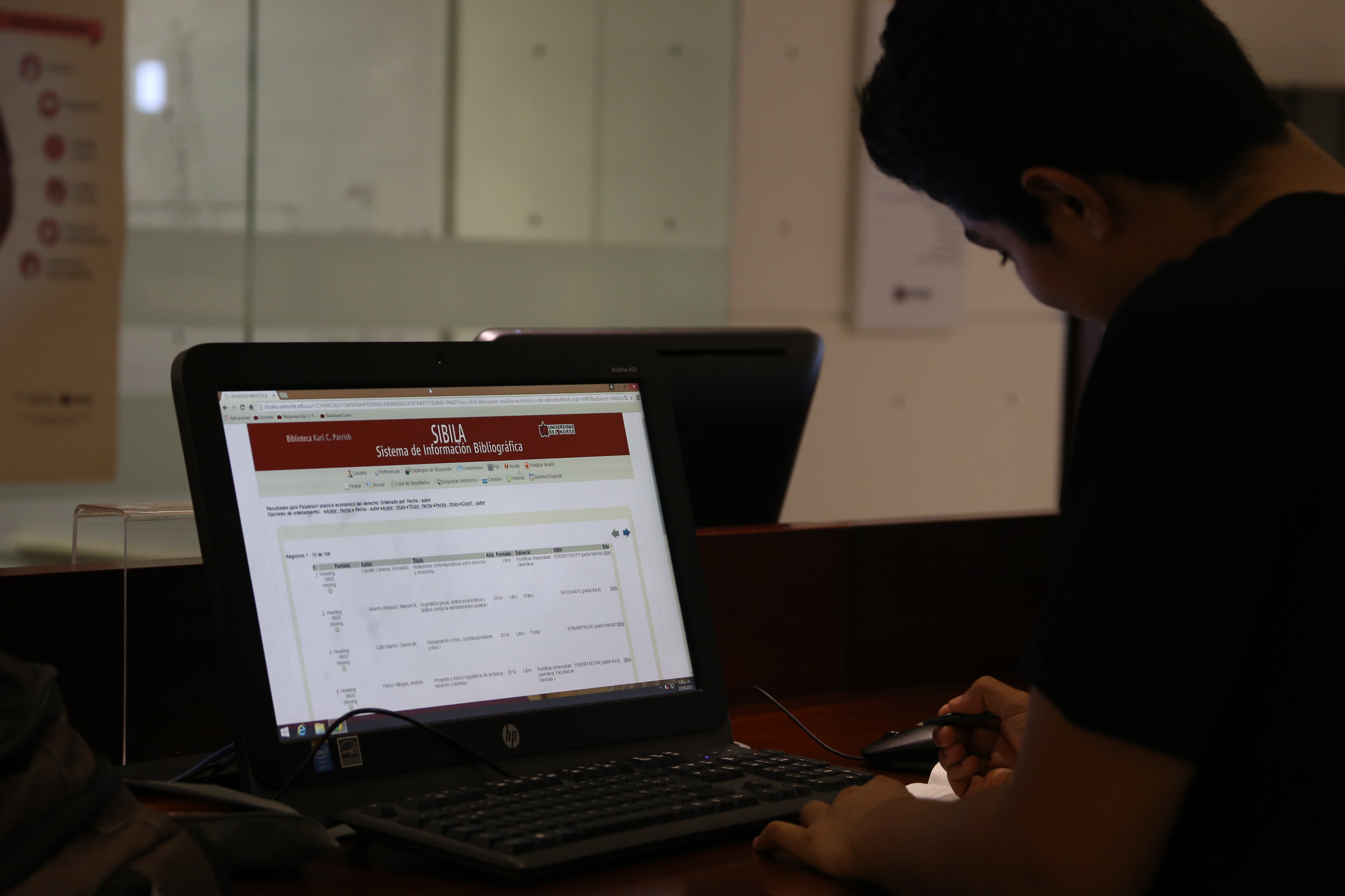 esta es una imagen de una persona revisando la base de datos de la biblioteca en un computador portatil